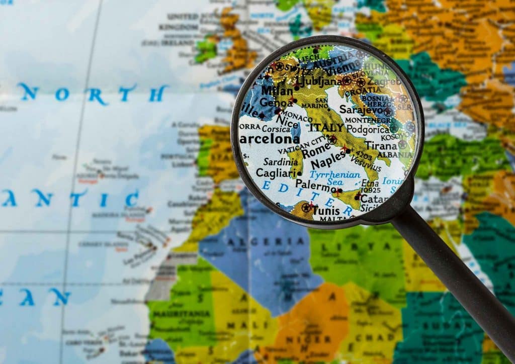 Mapa mundial com uma lupa dando zoom na itália